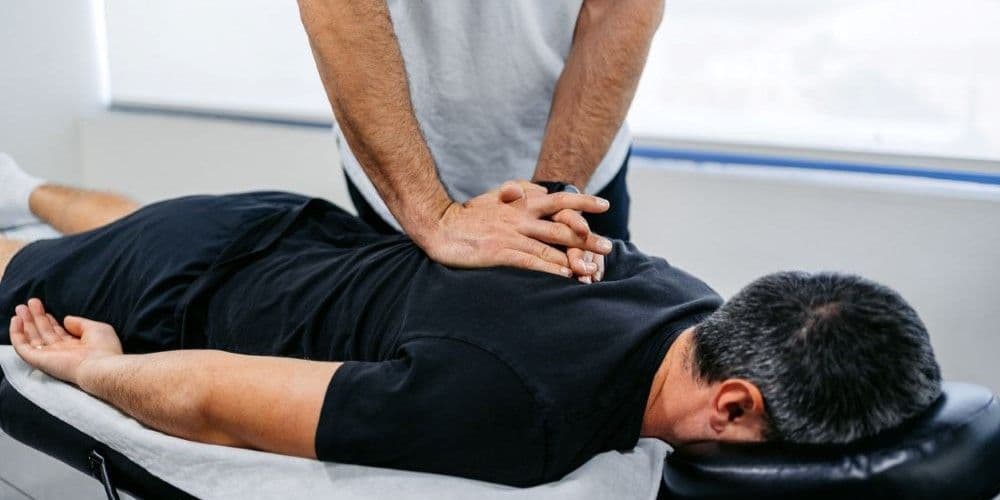 A Chiropractor giving his patient a chiropractic adjustment.